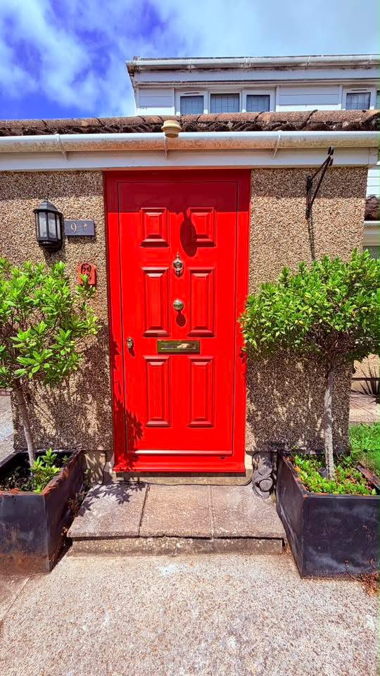 Gloss red six-panel composite front door with chrome knocker and letterplate
