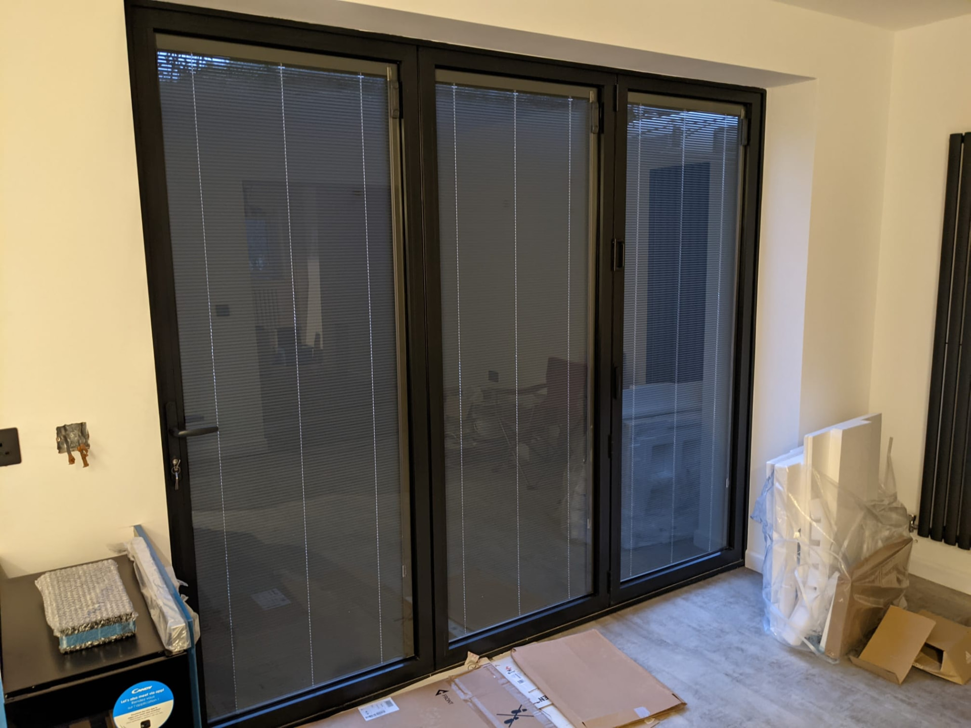 Large grey aluminium bi-fold doors with integrated blinds fitted internally
